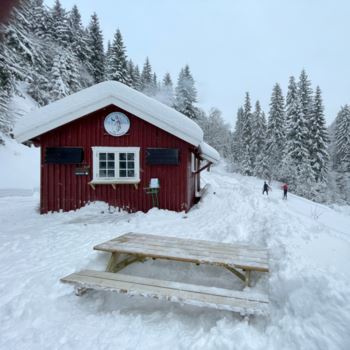 Storebekkhytta før åpning med en av benkene spadd frem fra snøen.