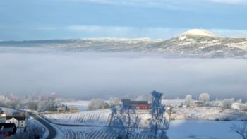 Et tåkesjikt splitter utsikten over Hadeland mot Hvalebykampen i Gran. Det er snø, men her i lia vest for Roa er det for lite til å gå på ski, da må vi opp til for eksempel Mylla.